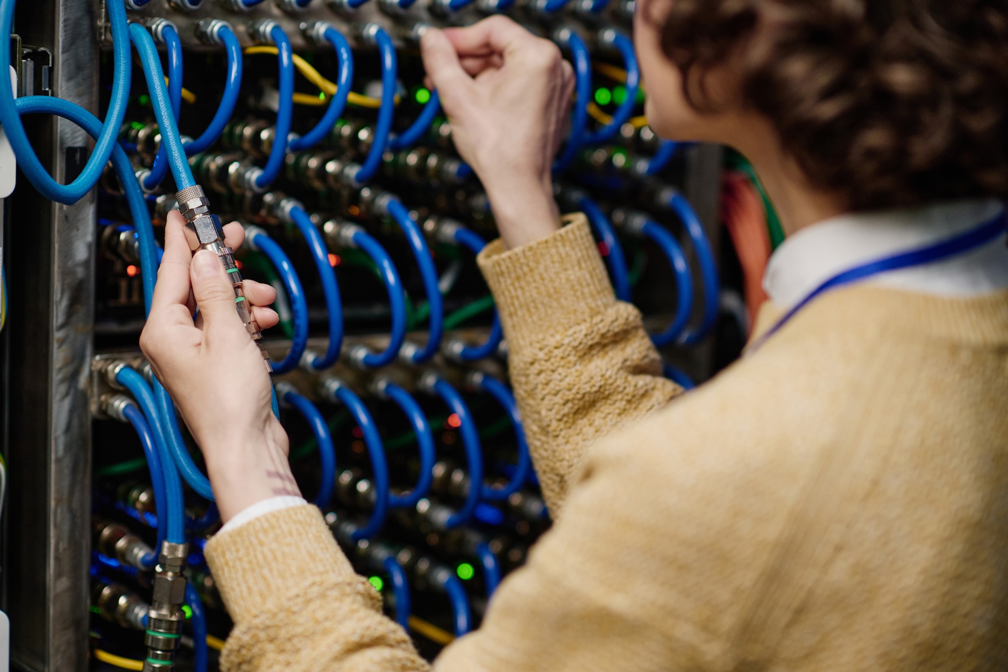 Female engineer connecting wires in server cabinet